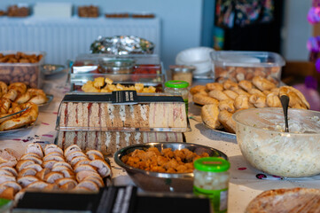 Buffet lunch selection at a celebration with pasty, sandwiches, sausages, salad, potato salad, cocktail sauages and other nibbles.