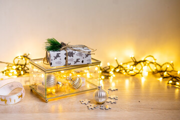 Winter cozy background with festive decor details, snow on a wooden table and bokeh.