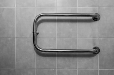 Steel towel rail on the tiled wall