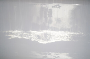 Texture. Reflections of light on the walls of the white bath. Abstraction.