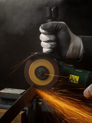 A man holding a circular saw with sparks on the black background