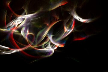 Colored lights forming abstract shapes and patterns on a black background. Free space to write.