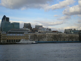 Fototapeta na wymiar La ville de Londres avec ses bâtiments en pierre ou un peu en verre, avec une Tamise calme et plaine, ville sous un ciel bleu et avec un peu de nuages, vie et zone urbaine britannique