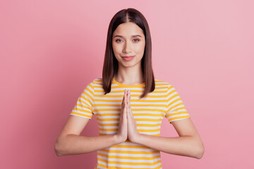 Photo of adorable charming sincere lady hold palms together plead help on pink background