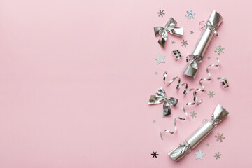 Christmas crackers with shiny confetti on color background, top view, copy space