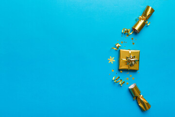 Christmas crackers with shiny confetti on color background, top view, copy space