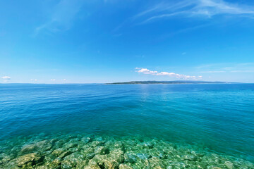 Fototapeta premium Summer vacation concept. Blue transparent sea water texture. Background of tranquil ocean water. Sea landscape with clear water.
