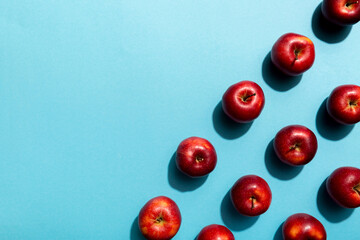 Many red apples on colored background, top view. Autumn pattern with fresh apple above view