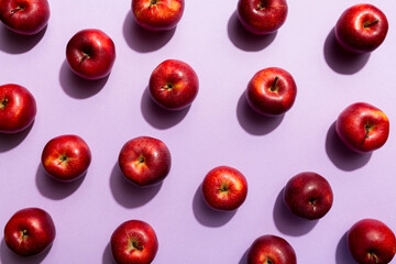Many red apples on colored background, top view. Autumn pattern with fresh apple above view