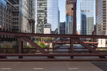Steel bridge over Chicago river cutting through downtown scene with glass skyscrapers