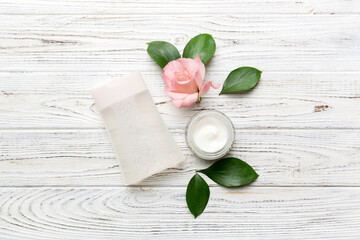 Composition with cosmetic products and beautiful roses on wooden background. Flat lay