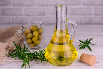 Olive oil in a glass decanter on a white background.