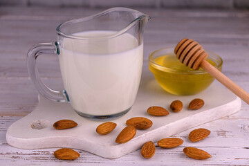 Almond milk in a transparent jug on a white background.	
