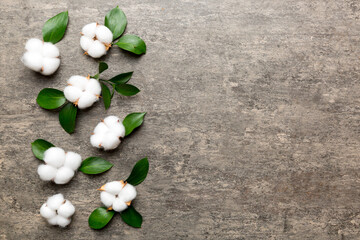 Naklejka na ściany i meble Autumn Floral Flat lay background composition. Dried white fluffy cotton flower branchwith green leaf top view on colored table with copy space