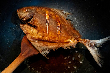 Crispy Fried Pomfret  in the frying pan,  Delicious and healthy