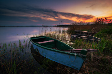 Obraz premium sunset on the lake and boat in wytyckie lake, poland lubelskie