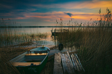sunset on the lake and boat in wytyckie lake, poland lubelskie