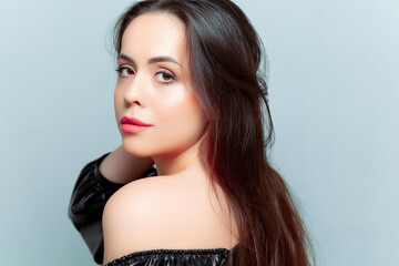 Fototapeta premium portraits of a beautiful brunette model who stands sideways and straightens her hair