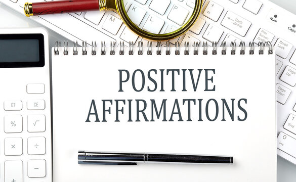 POSITIVE AFFIRMATIONS Text on notepad with calculator and keyboard