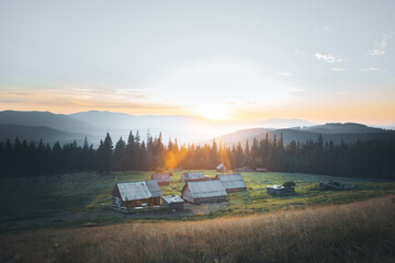 mountain landscape with small houses and sunset