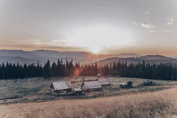 Naklejka premium mountain landscape with small houses and sunset