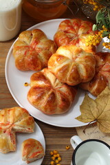 Pumpkin buns with milk and honey on wooden background