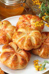 Pumpkin buns with milk and honey on wooden background