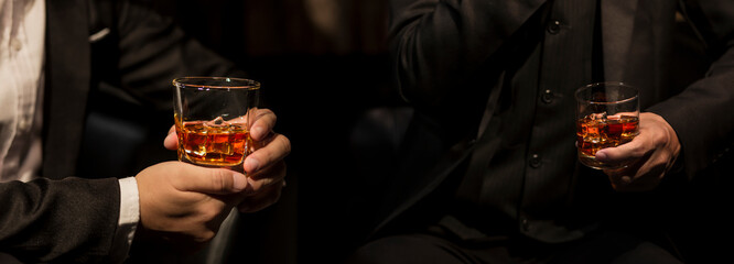 Closeup businessmen holding a glass of whiskey