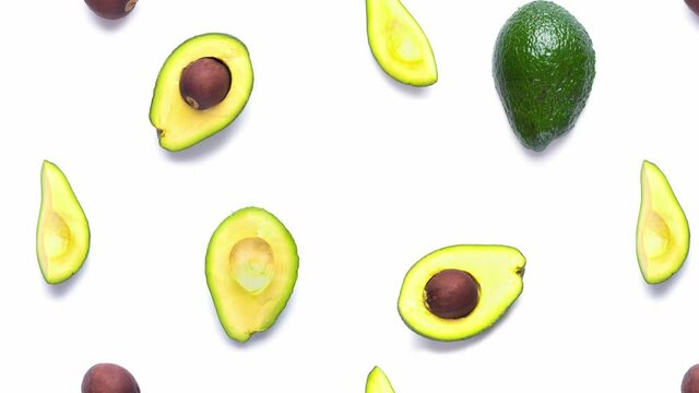 Background made from isolated avocado pieces on white background. Flat lay of whole and half avocados, avacado pieces and seeds.