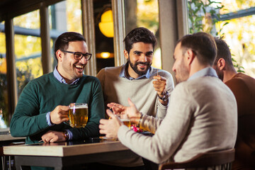 Group of friends drinking beer in pub