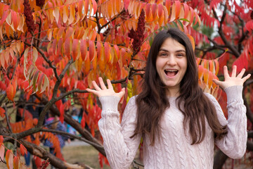 A 25-year-old brunette woman with long hair with her mouth open shows a gesture with a lot of hands.