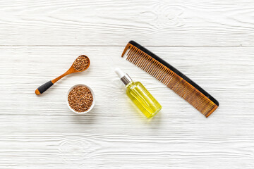 Sesame oil for hair care with wooden hair brush. Top view