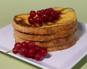 Traditional French toast with red currants. Fried bread soaked in a mixture of milk, eggs and sugar.
