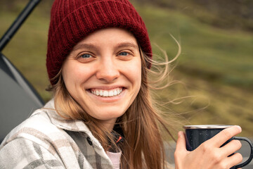 Woman stands alone on a rural road and looks into the camera with wide smile © Yakobchuk Olena