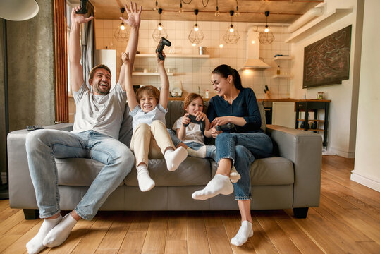 Smiling Family With Kids Play Video Game Together