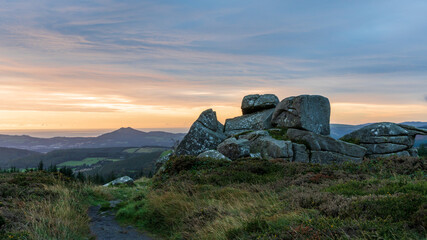 Sunrise over the southernmost tor on the summit of Three Rock mountain in Dublin, Ireland. Large granite rock formation landscape.