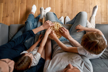 Top down of family with kids eat snacks relax