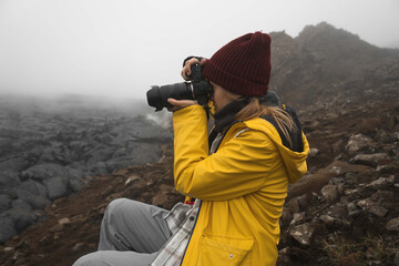 Travel female photographer with professional telephoto lens camera shooting wildlife