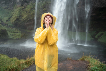 Woman standing with prayer gesture and looking up with smile while enjoying of her trip