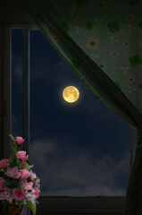 Full moon in window view with green curtain