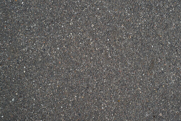 Dark gray rough asphalt, top view. Textured surface background