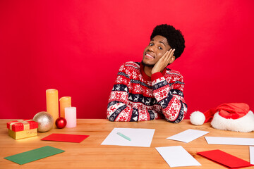 Naklejka premium Photo of young nice brunet guy sit work wear holiday sweater isolated on red color background