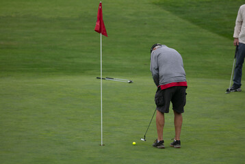 A Man Playing Golf on the Morro Bay Links with Putting to the Hole from the Green
