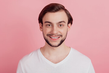 Fototapeta premium Portrait of positive cheerful handsome guy toothy beaming smile on pink background