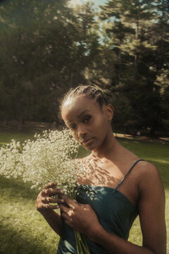 female model holding flowers in cornrows