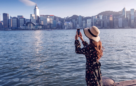 Asian woman traveler visiting in hong kong harbour, Hong Kong harbour located along the victoria harbor in Hong Kong