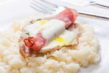 poultry meat baked with ham and cheese served with rice