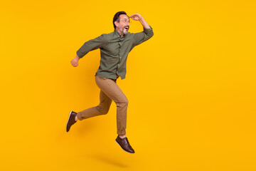 Fototapeta na wymiar Full length body size view of attractive amazed man jumping running looking far isolated over bright yellow color background