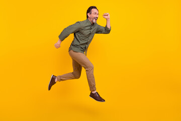 Full length body size view of attractive cheerful man employee jumping running isolated over bright yellow color background