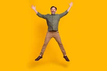 Fototapeta na wymiar Full length body size view of attractive lucky man jumping having fun isolated over vivid yellow color background